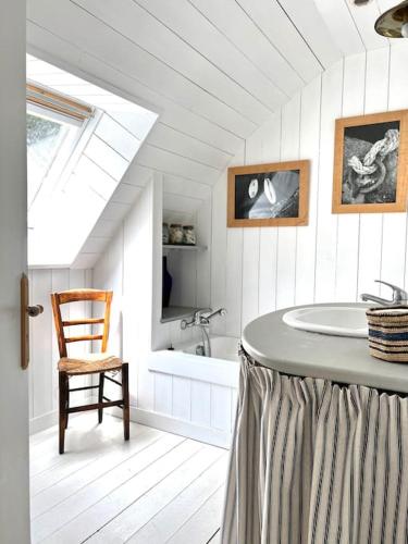 La salle de bains blanche est pourvue d'une baignoire et d'une chaise. dans l'établissement Fantastic 6 Bedroom House with stunning sea view, à Arzon