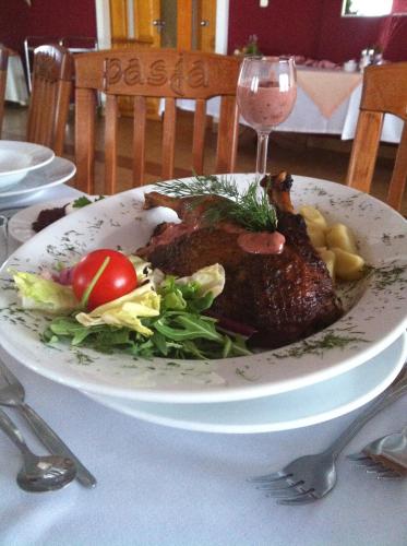 a plate of meat and a salad on a table at Zajazd Pasja in Sławków