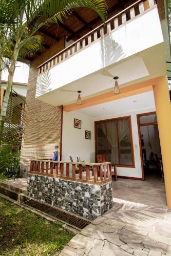 a house with a stone wall and a porch at Villa Lu Amazon Ecolodge in Tarapoto