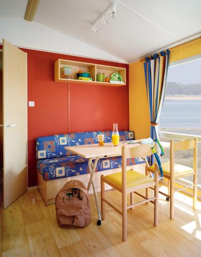 une chambre avec un lit, une table et des chaises dans l'établissement Camping Domaine de Mepillat, à Saint-Nizier-le-Bouchoux