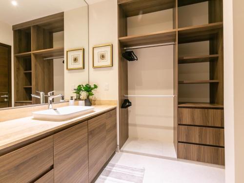 a bathroom with a sink and a closet at Elemental - Vista Villa Iii in Cabo San Lucas