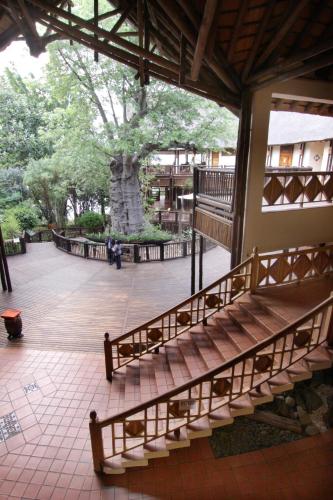 a group of benches in a building with a tree at Cresta Mowana Safari Resort & Spa in Kasane