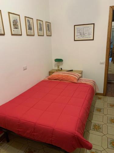 a red bed in a room with a red comforter at Anzio (RM), zona Santa Teresa in Anzio