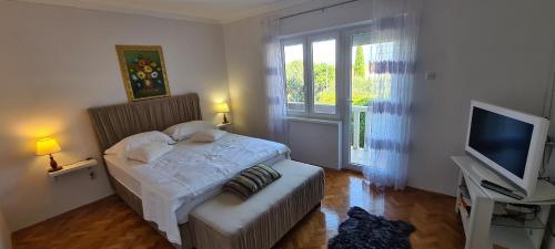 a small bedroom with a bed and a television at Apartmani Meri in Supetar