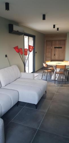 Cette chambre comprend 2 lits et une table ornée de fleurs rouges. dans l'établissement gite Lepigeonnier 26, à Piégros-la-Clastre