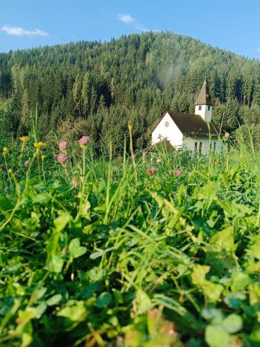 a church in the middle of a field with flowers at Ferienhütte Antonia in Kliening