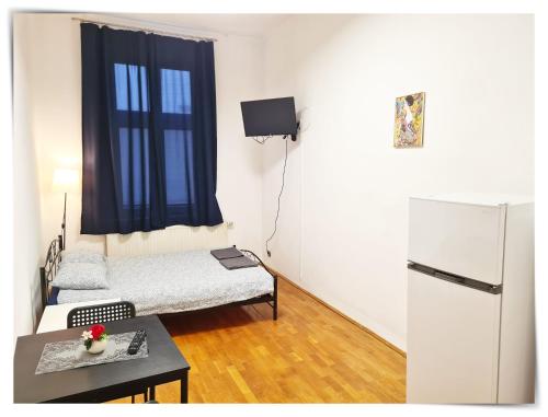 a small room with a bed and a refrigerator at SouvenirAppart Sniadeckich in Bydgoszcz