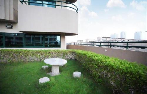 a white table in the grass in front of a building at Beautiful Partition Room in Barsha heights in Dubai