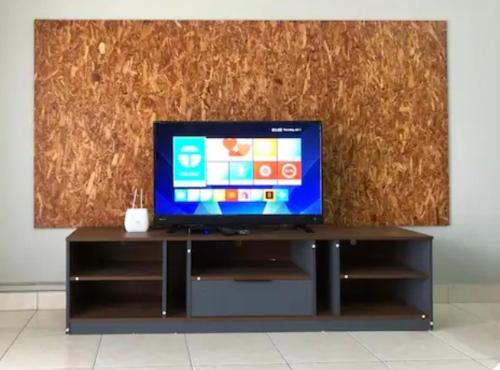 a flat screen tv sitting on a entertainment center at LSH Homestay Rawang in Rawang