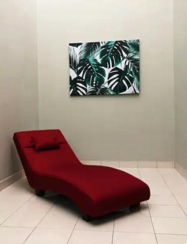 a red couch sitting on a white floor in a room at LSH Homestay Rawang in Rawang