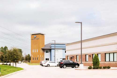 two cars parked in a parking lot in front of a building at Hotel Blue Spring in Spring