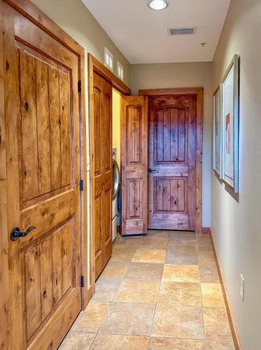 a hallway with wooden doors and a tile floor at GrayRock in Eagle