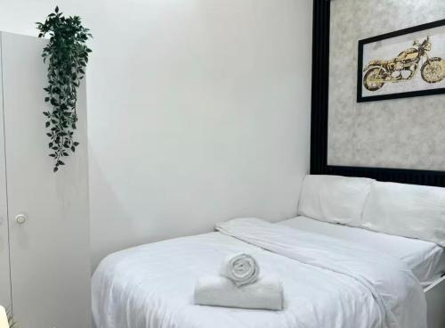 a bedroom with a white bed with a plant on it at Attraction Partition Room in Barsha heights Tecom in Dubai