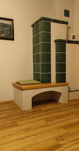 a green chair in a room with a wooden floor at Ferienhütte Antonia in Kliening