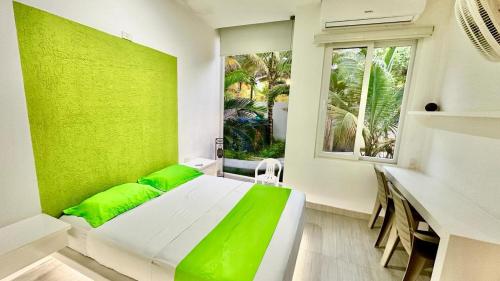 a green room with a bed and a window at PlayAkemi - Cojimies - Ecuador in Cojimíes