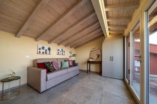 a living room with a couch and wooden ceilings at Casina Rossa in Peccioli