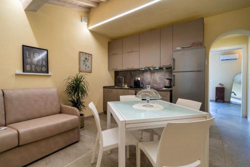 a kitchen and living room with a table and a couch at Casina Rossa in Peccioli