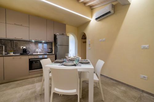 a kitchen with a white table and white chairs at Casina Rossa in Peccioli