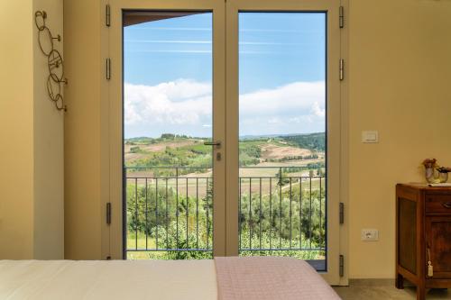 a bedroom with a bed and a glass door with a view at Casina Rossa in Peccioli