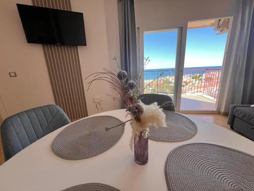 Una mesa blanca con un jarrón con flores. en Luxury La Mata, en Torrevieja