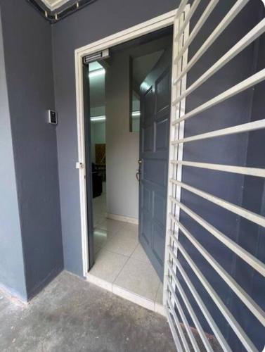 a hallway with a blue door and a mirror at LSH Homestay Rawang in Rawang