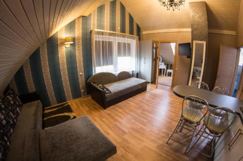 a living room with a couch and a table and chairs at Romance in Ventspils