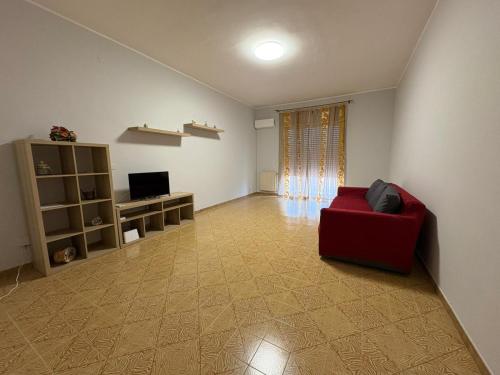 a living room with a red couch and a television at Stefano's house in Siracusa