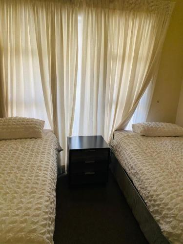a bedroom with two beds and a table between them at Khayalethu in Kempton Park