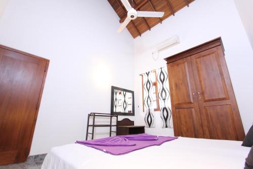 a bedroom with a bed and a wooden door at Angel villa in Negombo