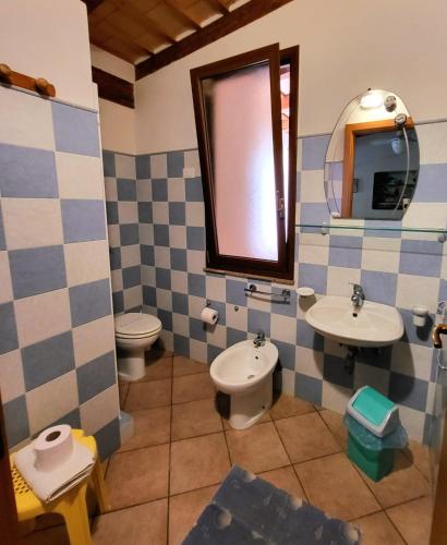 a bathroom with two sinks and a toilet and a mirror at Baglio Del Sole in San Vito lo Capo