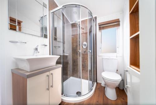 Un baño con ducha, inodoro y lavabo. en Primrose Valley Lakeside Lodge, en Filey