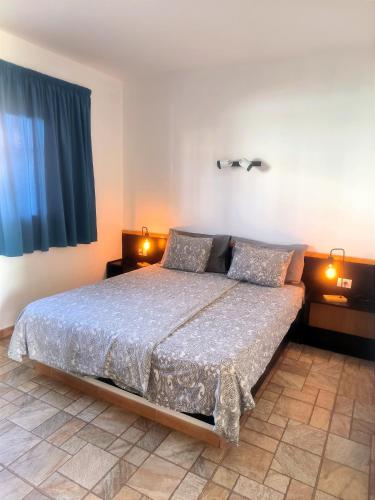 a bedroom with a large bed with two lamps at Apartamentos Alberto in Morro del Jable