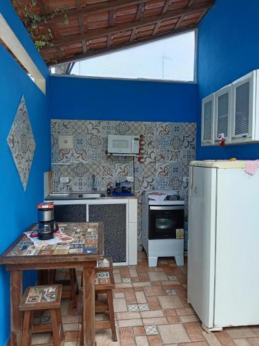 a kitchen with blue walls and a white refrigerator at Belo Suítes in Ubatuba
