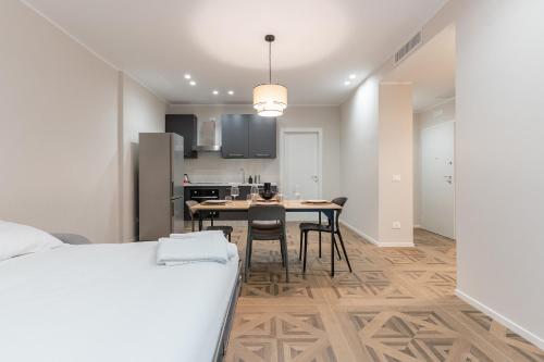 a bedroom with a bed and a kitchen with a table at Mica Home Calefati in Bari