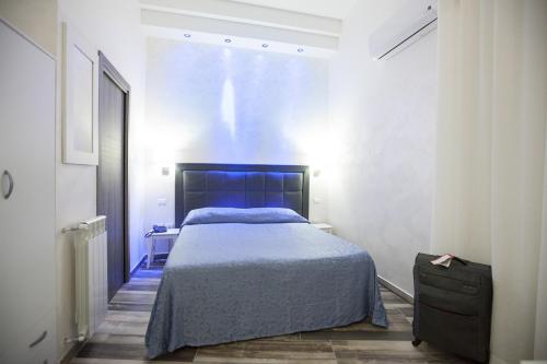 Un dormitorio con una cama azul y una ventana en Napoli Garibaldi Square, en Nápoles