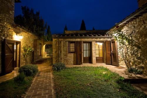 an old stone house with a courtyard at night at Le Mascie in Sovicille