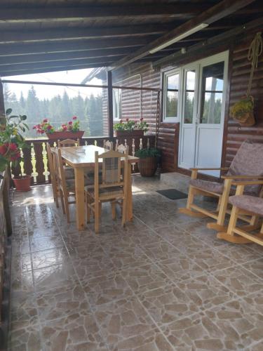 a patio with a wooden table and chairs at Casa din Deal-Apuseni in Ocoale