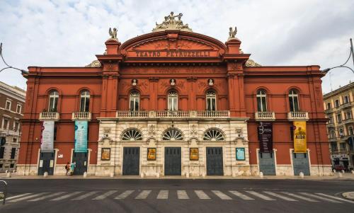 ein großes rotes Gebäude an der Ecke einer Straße in der Unterkunft Cavour Housing in Bari