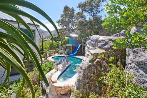 a backyard pool with a slide on a rock at Sunset Villa in Scarborough