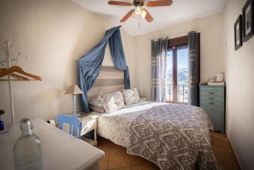 a bedroom with a bed and a ceiling fan at Eagles Nest - Massive townhouse with Pool with outstanding views in Algodonales