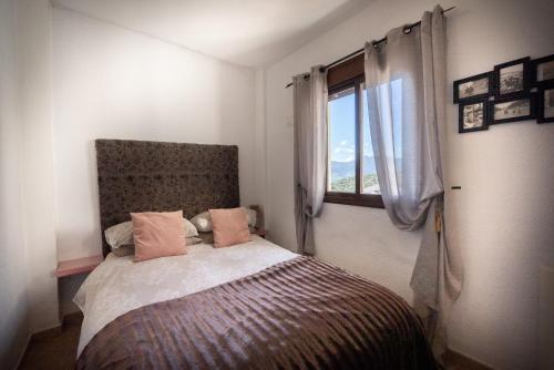 a bedroom with a bed with a window at Eagles Nest - Massive townhouse with Pool with outstanding views in Algodonales