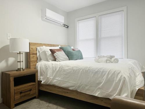 Un dormitorio con una cama con sábanas blancas y una ventana. en Riverside Retreat Apartments, en Evansville