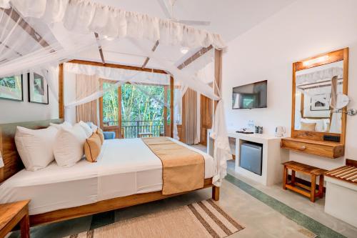 a bedroom in a villa with a bed and a television at Aurora in Unawatuna