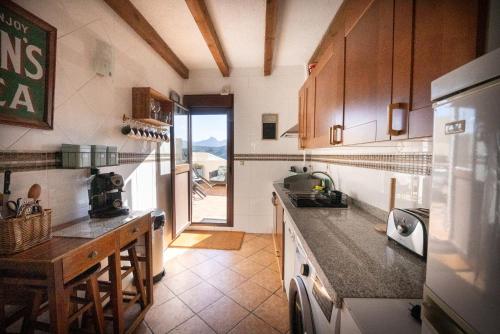 a kitchen with a counter top and a refrigerator at Eagles Nest - Massive townhouse with Pool with outstanding views in Algodonales