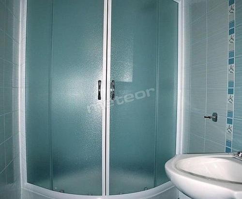 a shower with a glass door next to a sink at Pokoje u Piotra in Tczew
