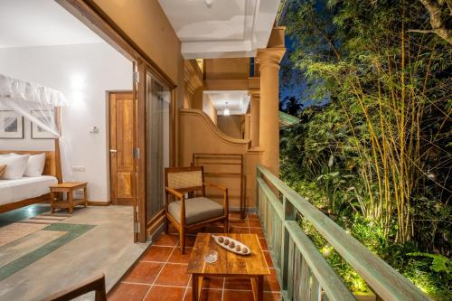 a room with a balcony with a bed and a table at Aurora in Unawatuna