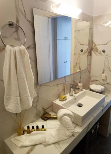 a bathroom with a sink and a mirror and towels at Sweet Home Nikorenia 1 in Krotiri