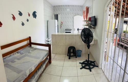 a room with a kitchen and a bedroom with a fan at Chalés Boraceia Duda in Boracéia