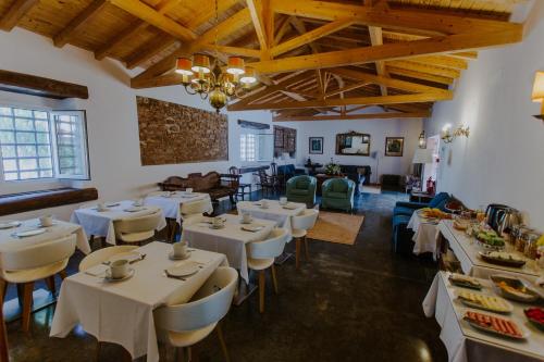 a dining room with white tables and chairs at Aba da Serra - Turismo Rural in Abrigada