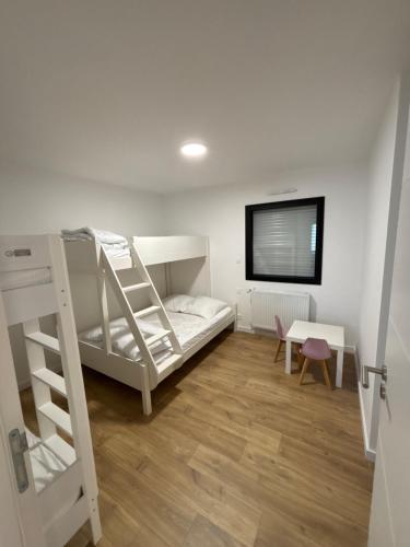 Cette chambre dispose de lits superposés, d'un bureau et d'une télévision. dans l'établissement Maison MADA SAINT CAST, à Saint-Cast-le-Guildo